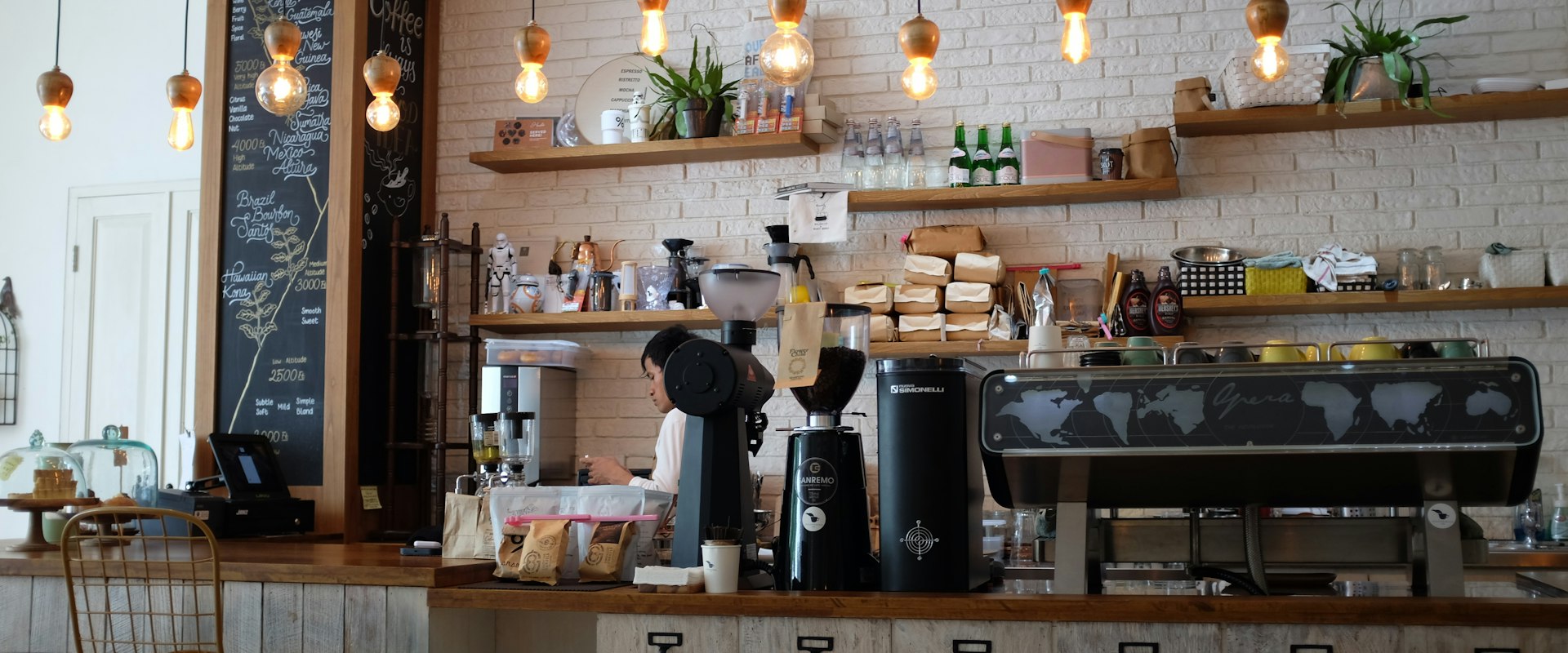 Interior of a modern cafe with warm lighting and coffee bar